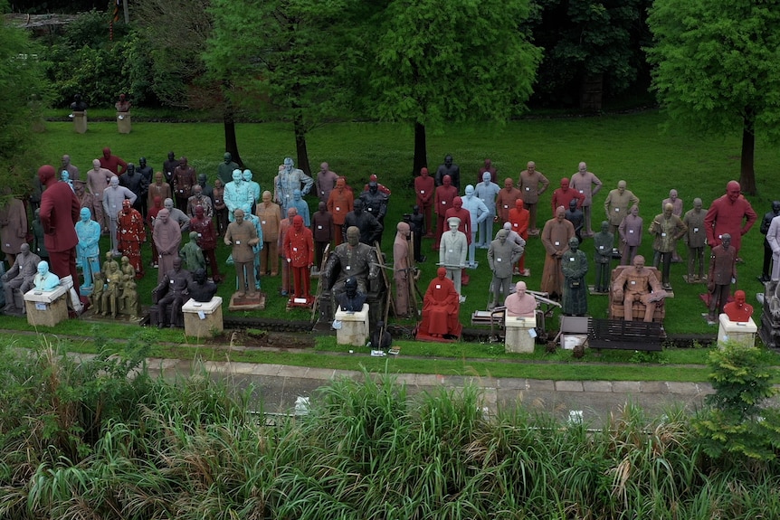 A park filled with lots of statues of the same man 