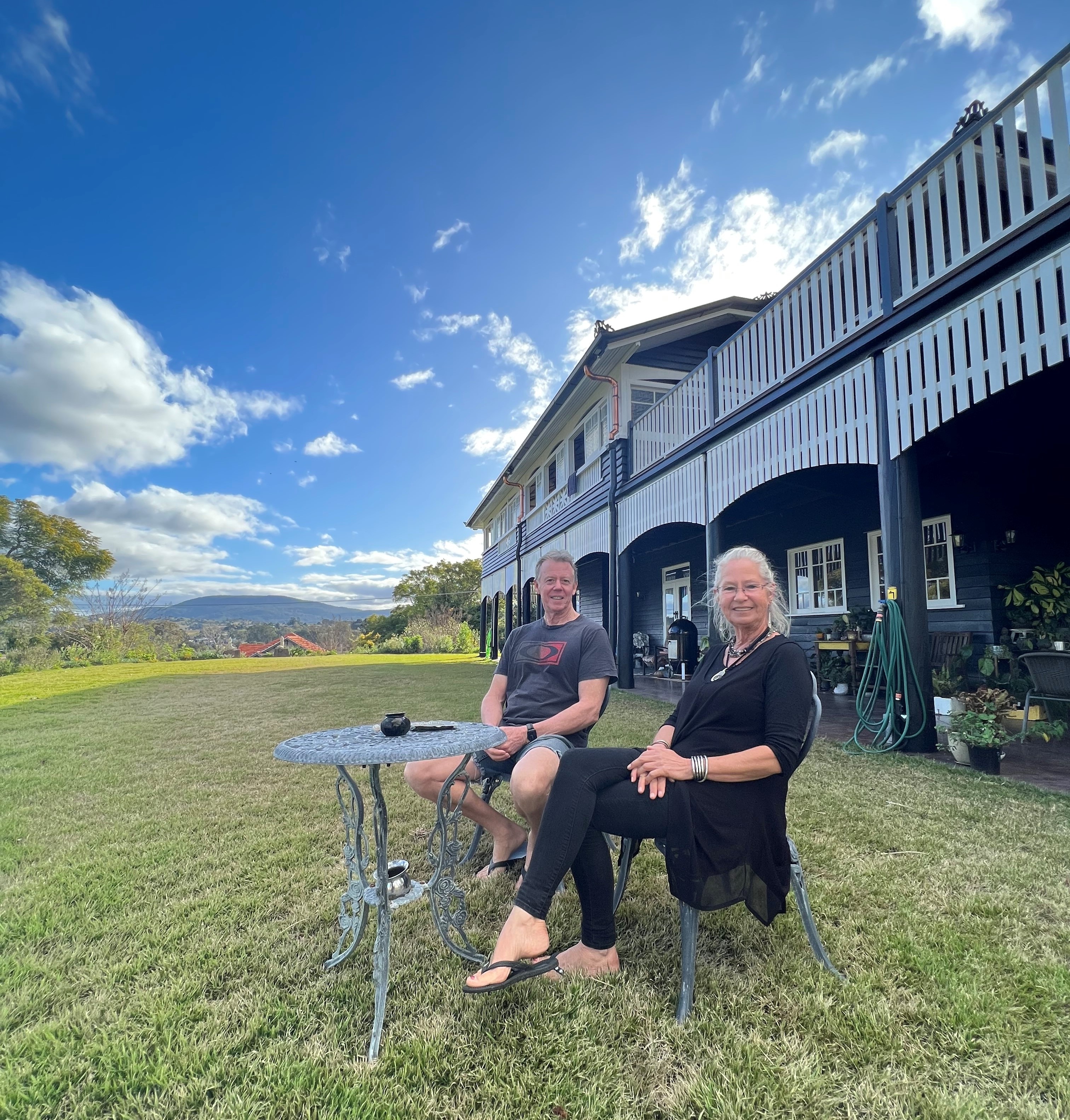 David and Julie Bland sitting out the front of their now-renovated Queenslander house that was moved from inner Brisbane.