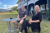 David and Julie Bland sitting out the front of their now-renovated Queenslander house that was moved from inner Brisbane.
