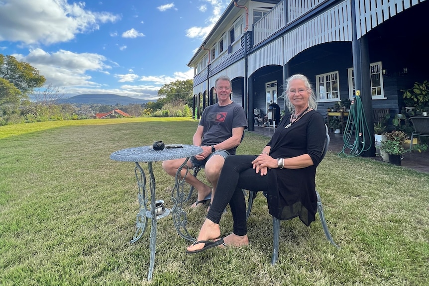 David and Julie Bland sitting out the front of their now-renovated Queenslander house that was moved from inner Brisbane.