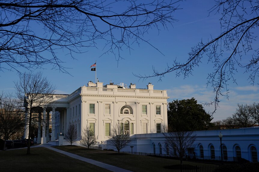 蓝天下，白色的白宫建筑物。