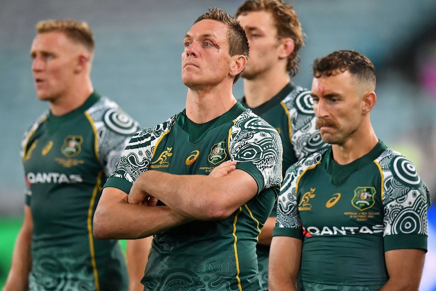 A number of Wallabies players stand around looking sad and disappointed