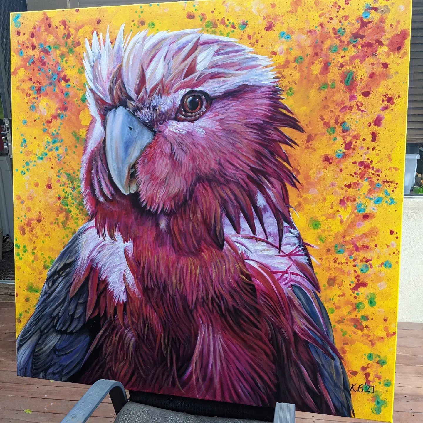 A large painting of a pink and white galah on a yellow background