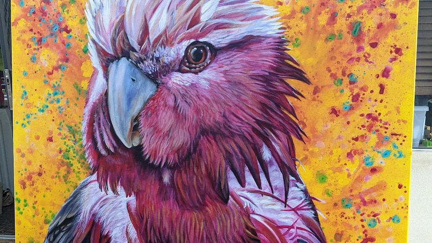 A large painting of a pink and white galah on a yellow background