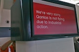 A Qantas worker adjusts a sign at Adelaide Airport to advise of more flight cancellations, October 31 2011. (ABC: Spence Denny)