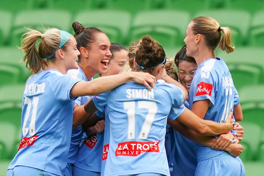 Melbourne City players hug each other as they celebrate a goal in the W-League grand final.