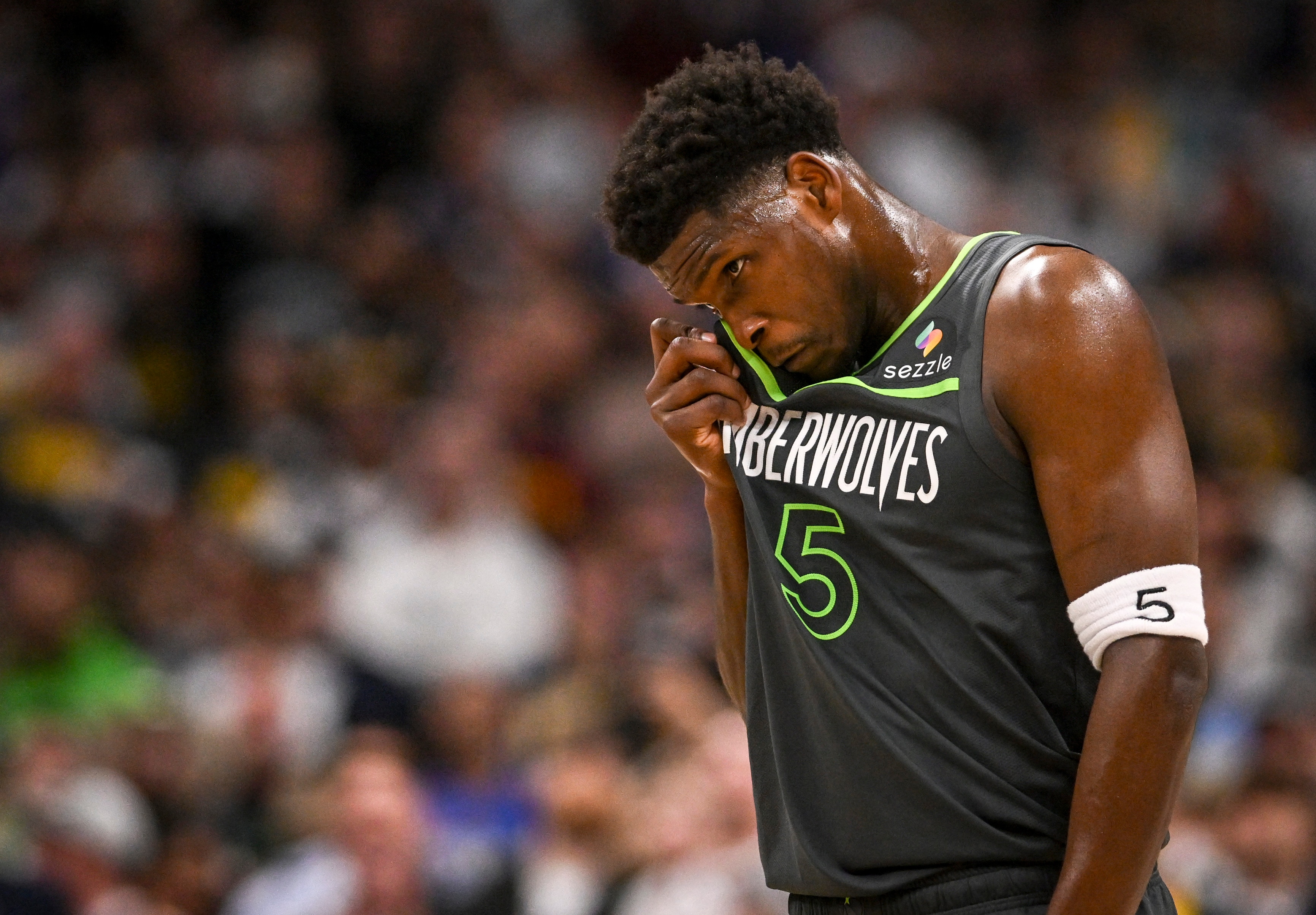 Anthony Edwards rubs his eye with his jersey