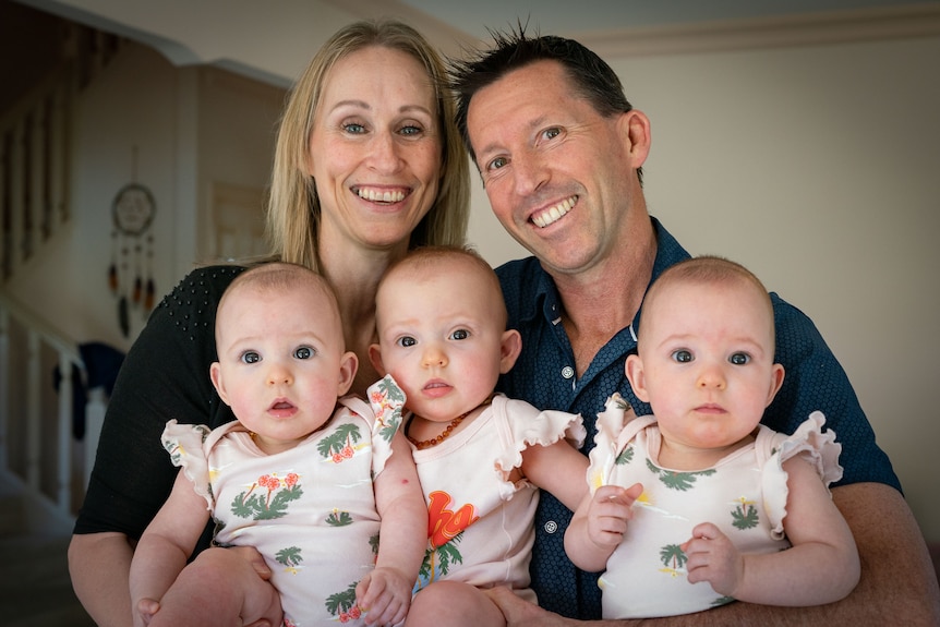 Triplets Liliana, Isabella and Charlotte Fitzgerald as babies with smiling mum and dad Leonie and Peter