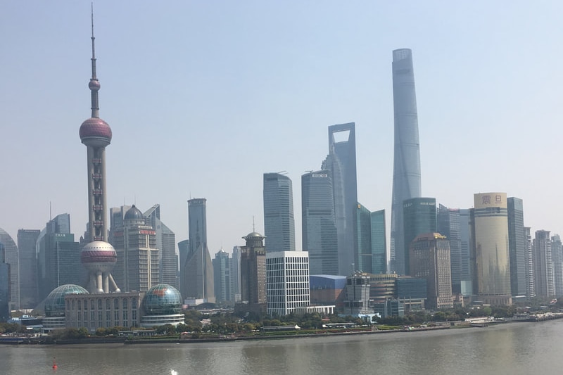 A cityscape of tall buildings across a river.