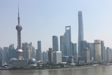 A cityscape of tall buildings across a river.