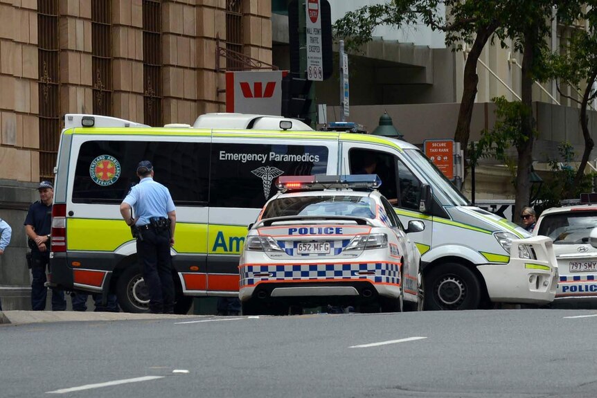 An ambulance leaves the Brisbane CBD with an alleged gunman