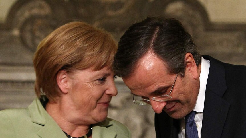 Greece's prime minister Antonis Samaras (right) listens to Germany's chancellor Angela Merkel before their press conference