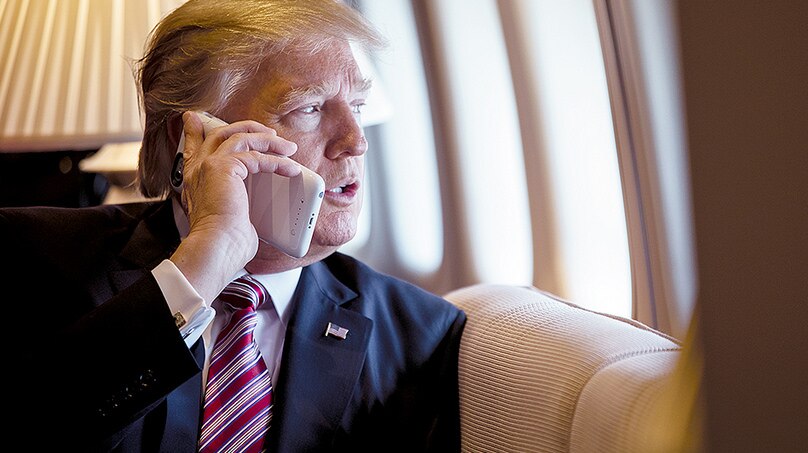 US President Donald Trump talks on the phone aboard Air Force One.