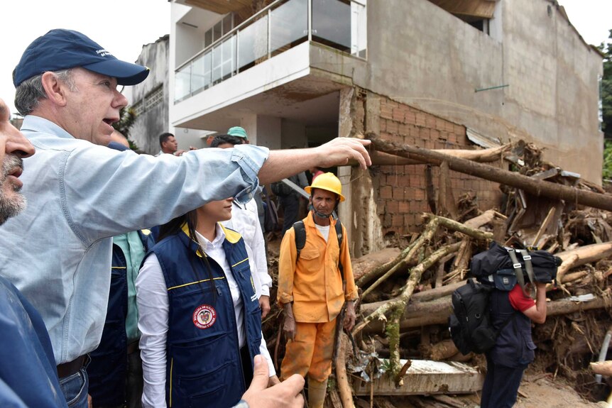 Colombia's President Juan Manuel Santos points as he visits the devastated region