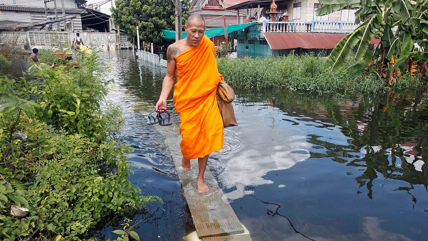 A Buddhist monk wades through a flooded street in Nonthaburi province, on the outskirts of Bangkok on October 16, 2011.