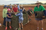 Kids help lay a pallet of turf at the Rolleston oval