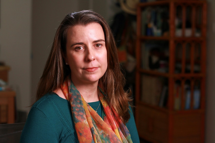 A middle aged woman in a green shirt wearing a scarf