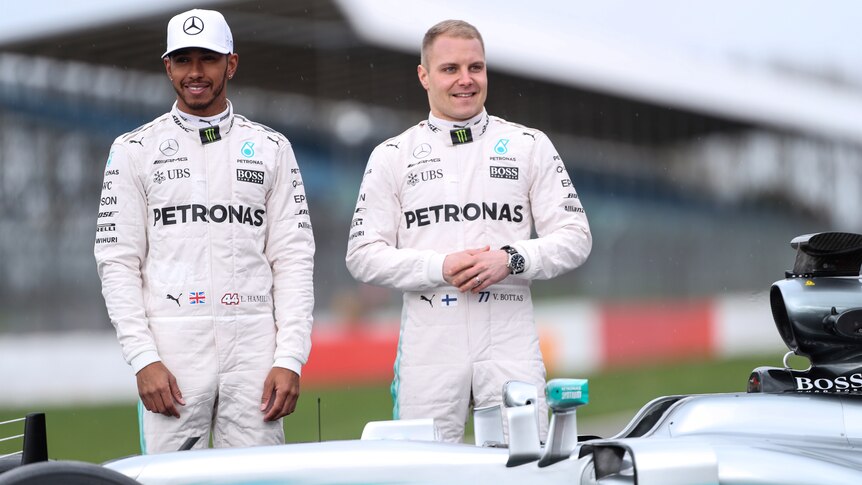 Lewis Hamilton and Valtteri Bottas pose by Mercedes F1 car