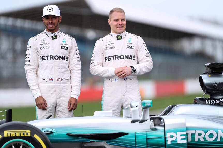 Lewis Hamilton and Valtteri Bottas pose by Mercedes F1 car