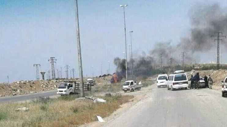 Black smoke rises ahead of cars stopped on a road into the Syrian city known as Castello Road.