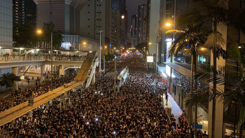 Hundreds of thousands of people fill up the streets of urban Hong Kong at night