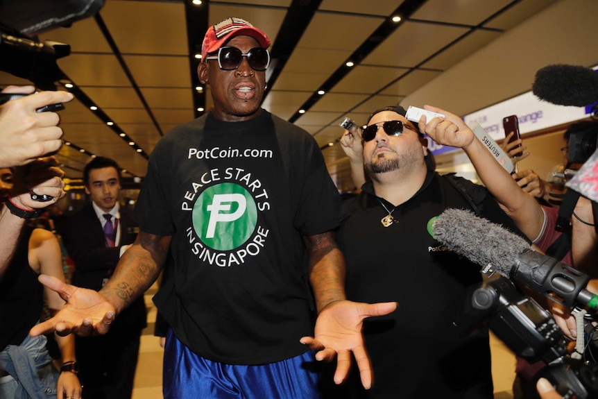 Dennis Rodman speaks to press as he arrives at Changi airport