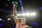 Tyson Fury raises a gloved fist and sticks his tongue out while his team lifts him on their shoulders after a heavyweight fight.