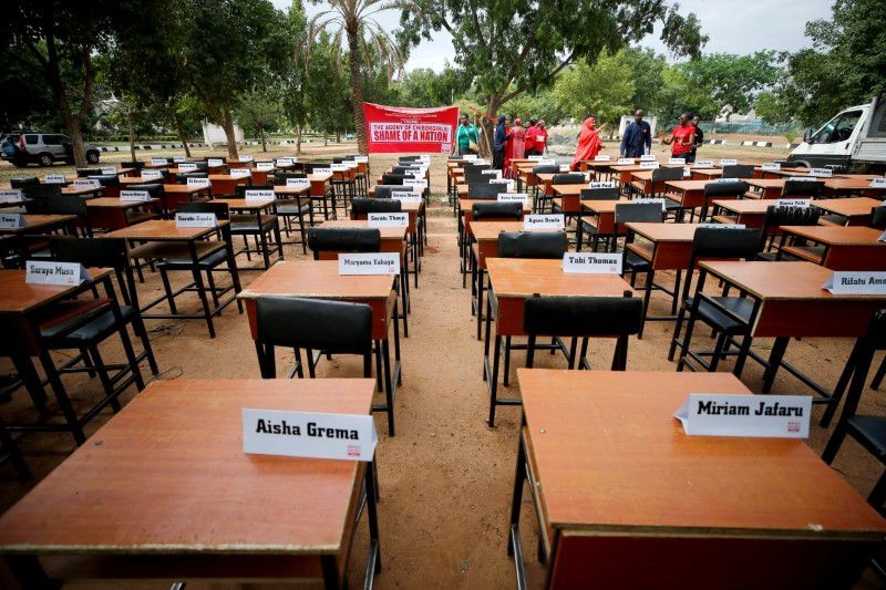 school desks outdoors with name card on top of them