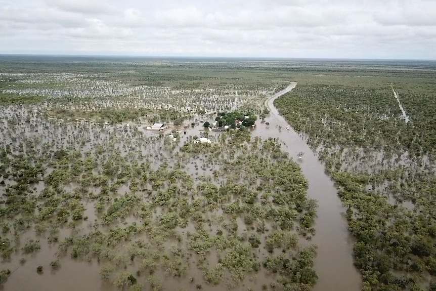 An aerial view of a flooded roadside restaurant in the outback