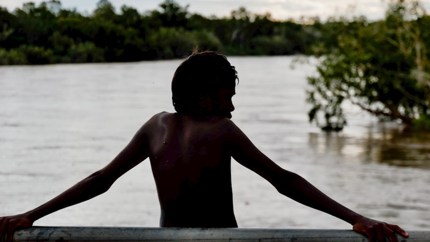 A boy stands looking over the Kimberley's Fitzroy River