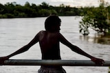 A boy stands looking over the Kimberley's Fitzroy River