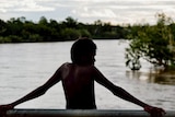 a young boy in front of a creek