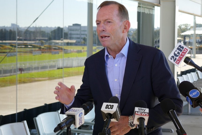 Tony Abbott speaks to media, microphones in front of him