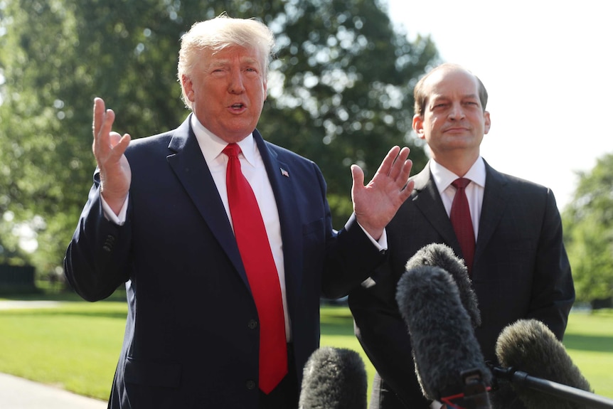 President Donald Trump speaks to members of the media with Secretary of Labor Alex Acosta.