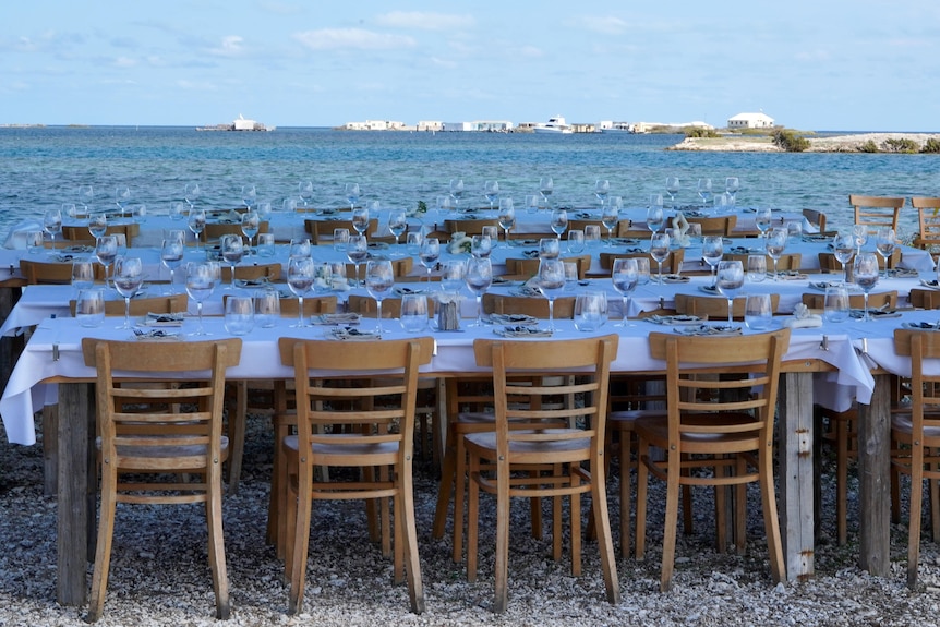 tables set with glassware by the water 