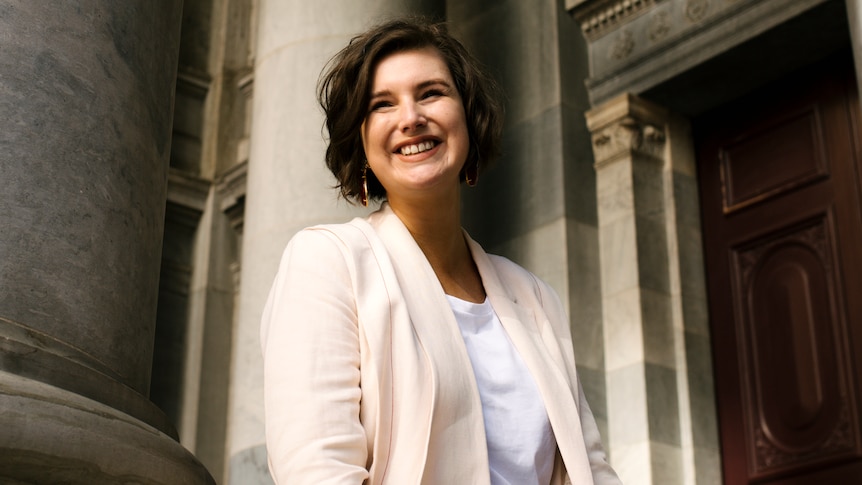 A woman with short hair smiles at the camera