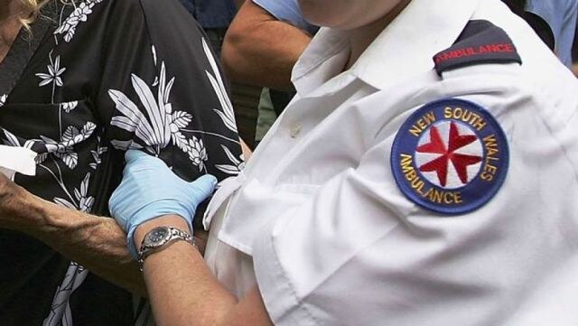 NSW ambulance service generic logo on sleeve, helping a patient