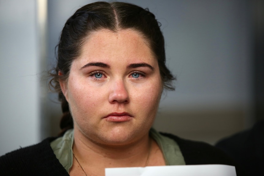 A woman with blue eyes and dark hair crying.