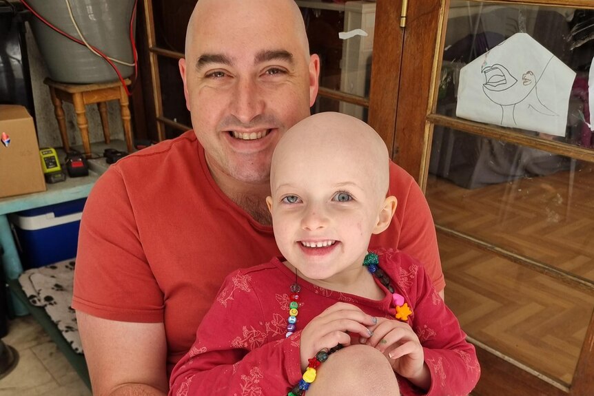 A man and a child with shaved heads,