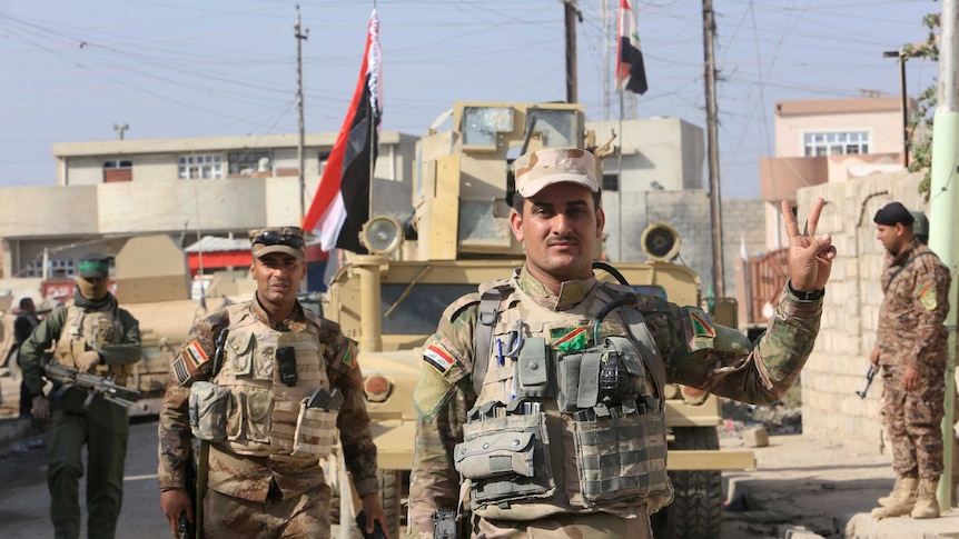 An Iraqi soldier gestures along a street in the Intisar district of eastern Mosul, Iraq, November 14, 2016.