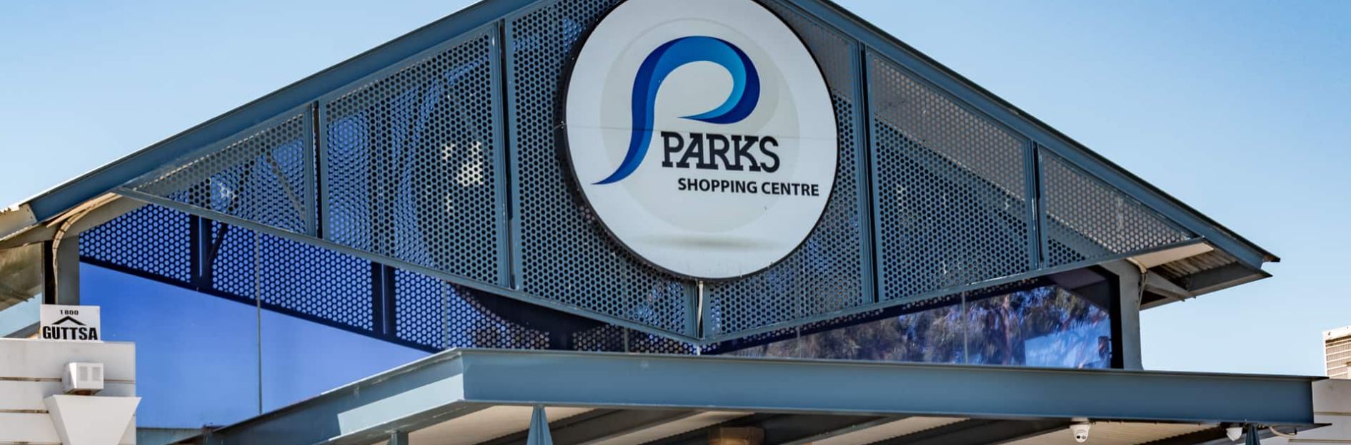 A sign on the top of a building saying Parks Shopping Centre