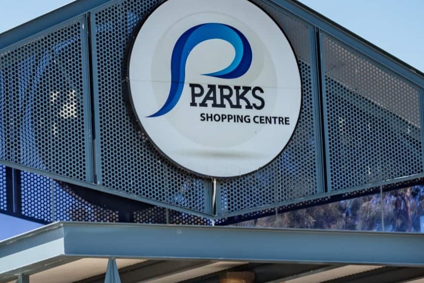 A sign on the top of a building saying Parks Shopping Centre