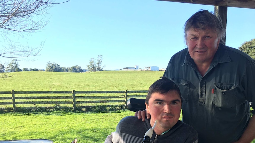 John Frankcombe is in his wheelchair, beside his dad Kevin on their dairy farm at Mt Hicks in north-west Tasmania.