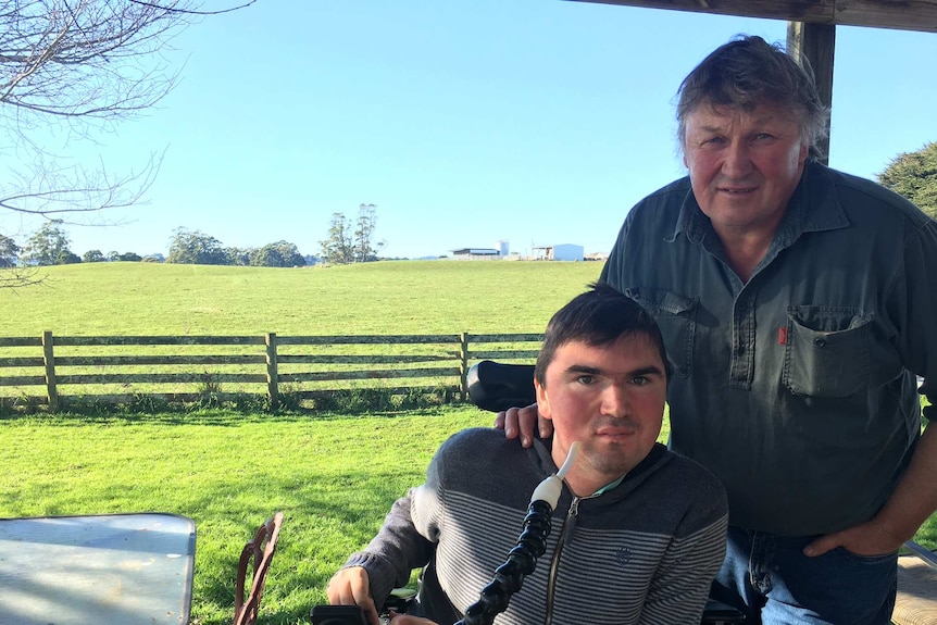 John Frankcombe is in his wheelchair, beside his dad Kevin on their dairy farm at Mt Hicks in north-west Tasmania.