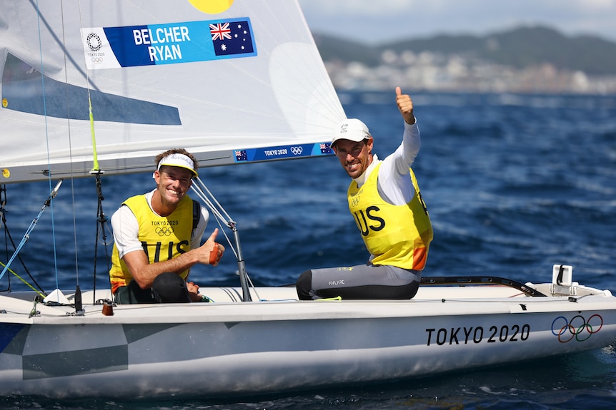Men's sailing team giving the thumbs up after a race