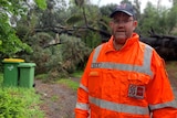 A man wearing glasses and an orange SES jacket.
