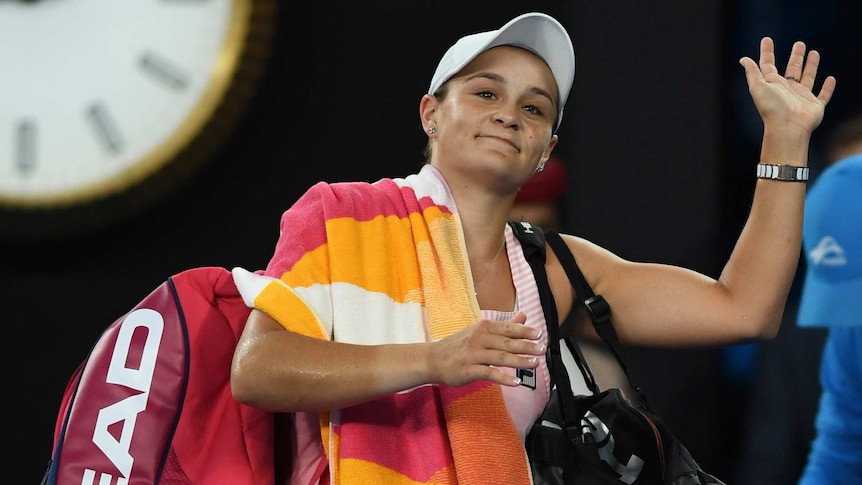 Ash Barty raises her hand in salute to the Melbourne Park crowd after losing at the Australian Open.