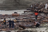 Local residents look at the debris at a beach after a storm in Santa Cruz, California.