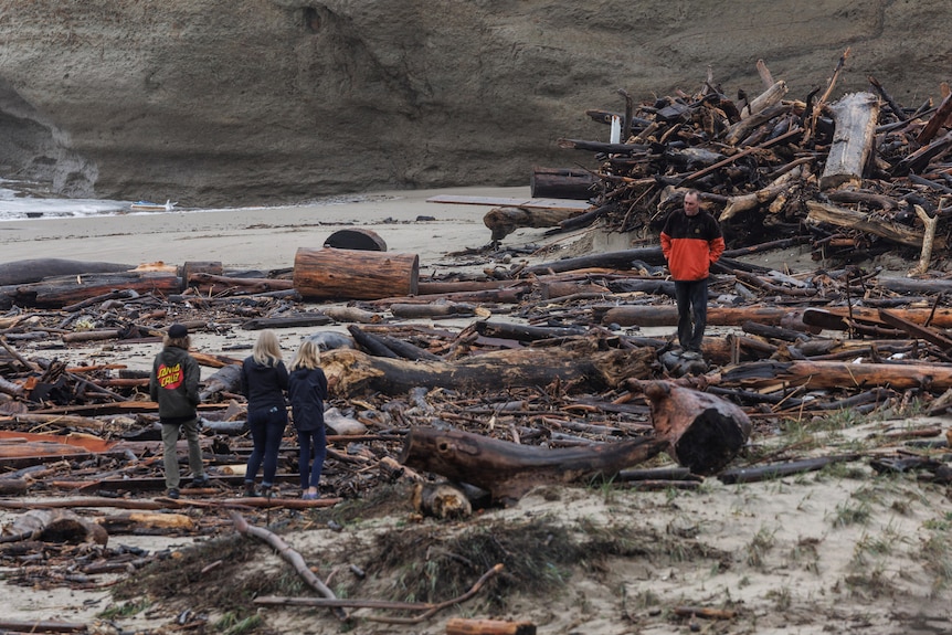 Local residents look at the debris at a beach after a storm in Santa Cruz, California.