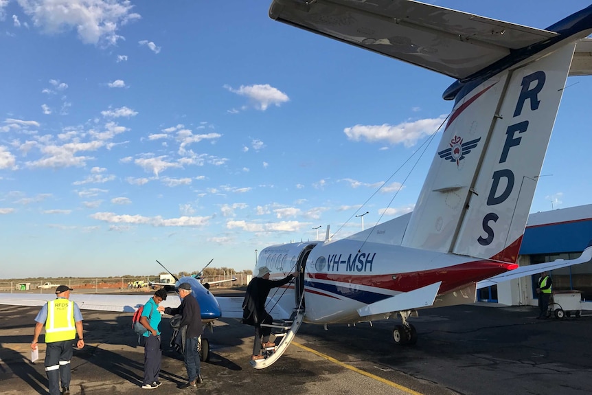 A Royal Flying Doctor Service plane sitting on the tarmac as passengers board